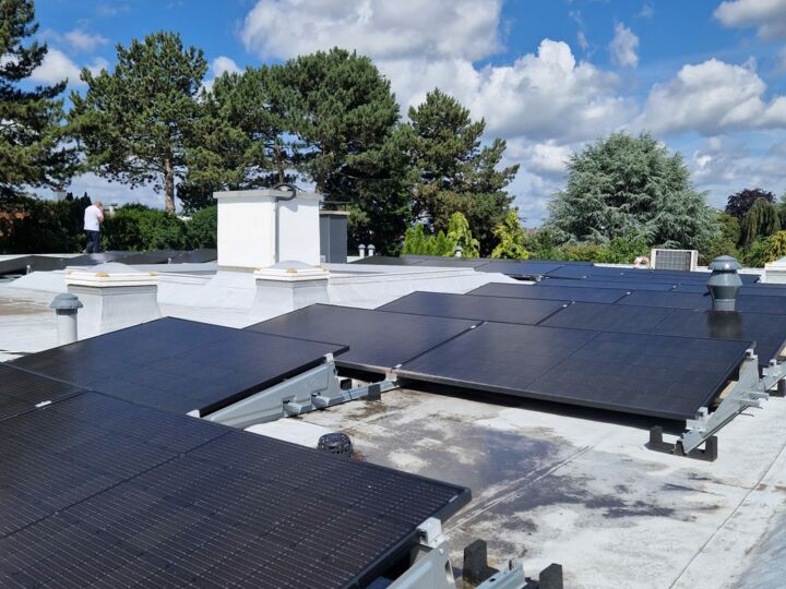 Auf einem Flachdach sind leicht angewinkelte Solarmodule installiert